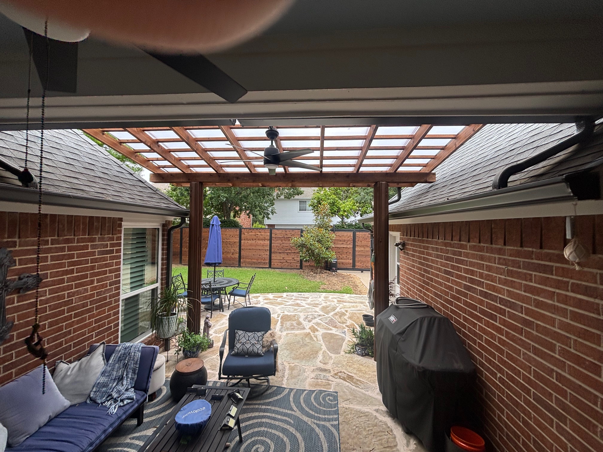 Covered patio with pergola-style cover built by Concord Roofing & Construction