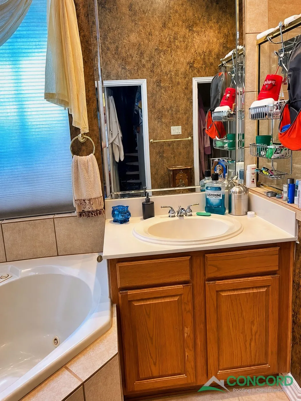 Master bathroom in Frisco, TX before the remodel, with a wood vanity, a corner jetted tub, and a brass-framed shower
