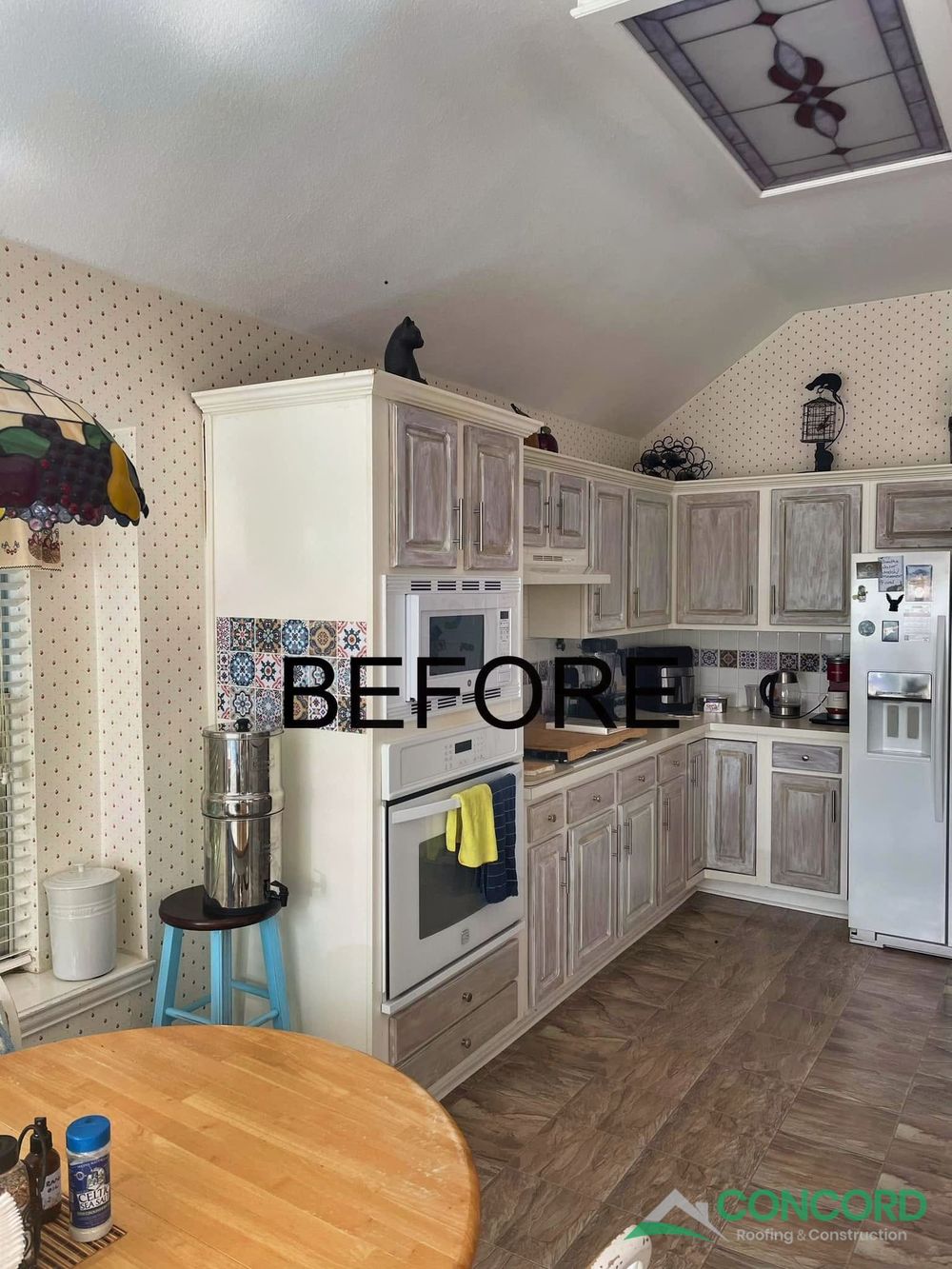 McKinney kitchen before the remodel, seen from the dining area, with a tall wall oven and microwave cabinet and a stained-glass ceiling light
