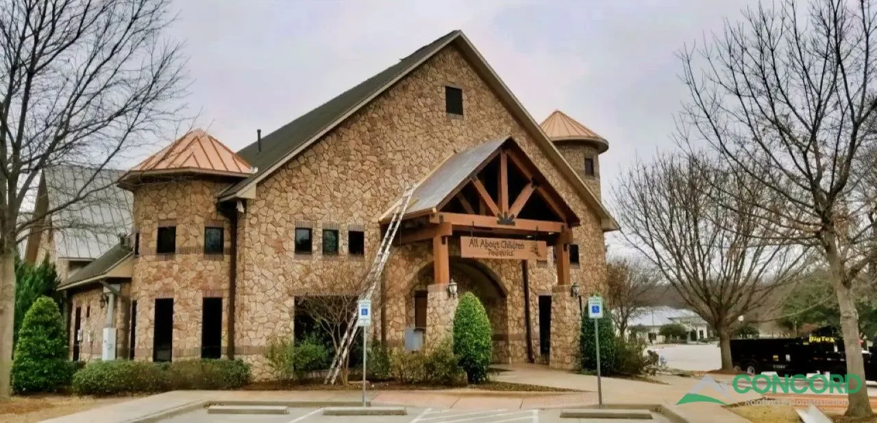 Accent-color metal roofing on the turrets and front entry of a pediatric clinic in McKinney, TX