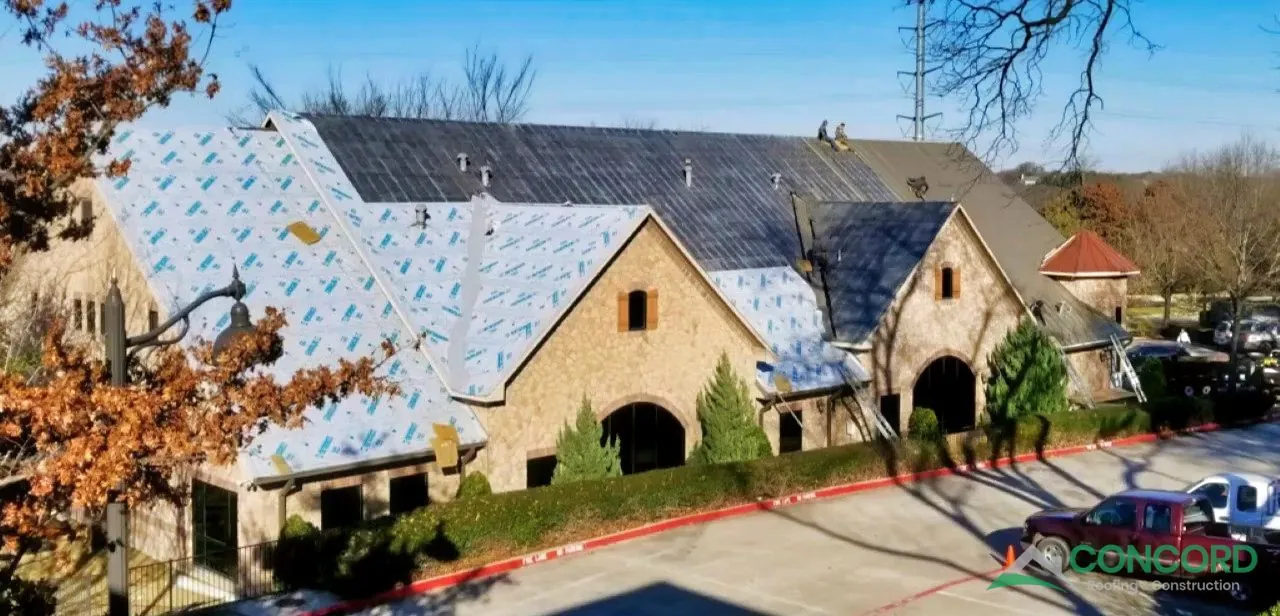 Underlayment in place as standing seam metal roofing gets started on a McKinney, TX commercial building