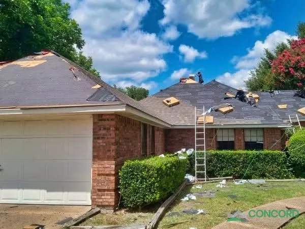 Crew installing synthetic felt on the roof of a single-story brick home with an attached garage in Waxahachie, TX
